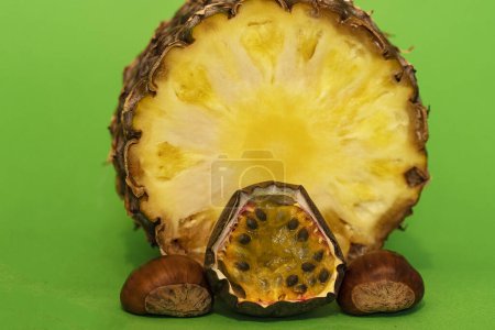 Photo for Pineapple fruit with maracuja and chestnuts isolated on green background - Royalty Free Image