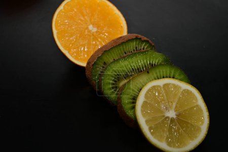 Foto de Rodajas de naranja y kiwi en el fondo negro - Imagen libre de derechos