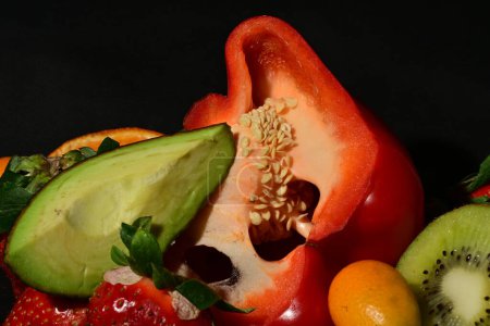 Téléchargez les photos : Groupe de fruits et légumes avec gelée roulée sur fond noir - en image libre de droit