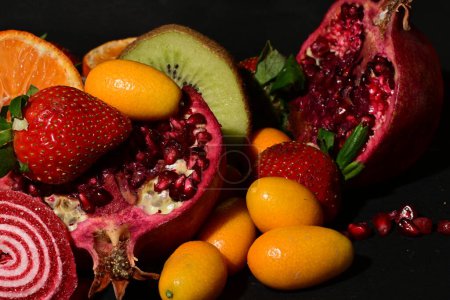 Téléchargez les photos : Groupe de fruits avec gelée roulée sur fond noir - en image libre de droit