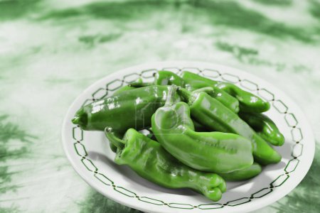 Teller mit süßer grüner Chilischote, auch bekannt als goldener griechischer oder toskanischer Pfeffer, der als Zutat für Salate und Kompott verwendet wird
