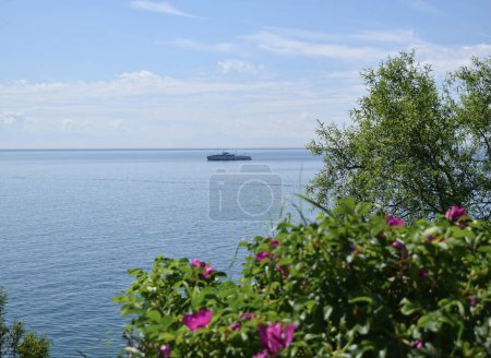 Photo for Lake Baikal in Russia, Siberia with vegetation and a ship in distance. - Royalty Free Image