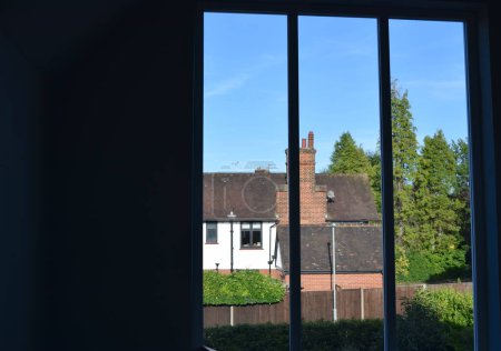 Téléchargez les photos : Vue fenêtre avec maison anglaise par une belle journée. - en image libre de droit