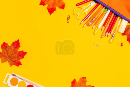Photo for Pencil box with pens on a yellow background with maple leaves. Flat lay. Copy space. Concept of back to school. - Royalty Free Image