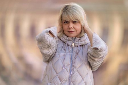 Photo for Psychology and mental health. Portrait of Caucasian adult woman holding at her head. Defocused twisted background. Concept of dizziness, headache and stress. - Royalty Free Image