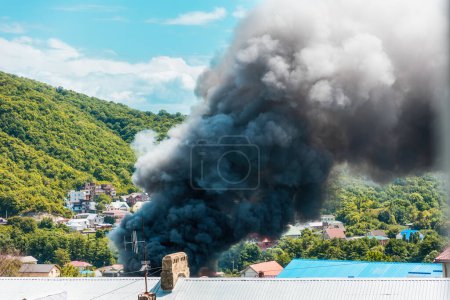 Téléchargez les photos : Du feu. Gros plan de nuages de fumée noire au-dessus d'un bâtiment en feu. Le concept d'urgence, de catastrophe et d'assurance. - en image libre de droit