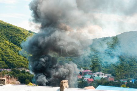 Fuego. Cierre de nubes de humo gris sobre un edificio en llamas. Concepto de accidente de emergencia, desastre y seguro.