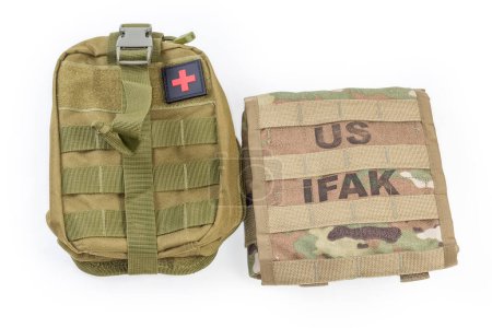 Deux pochettes militaires textiles pour trousse de premiers soins individuelle couleur protectrice, l'une d'elles appliquée dans l'armée américaine avec inscription US IFAK, vue du dessus sur fond blanc