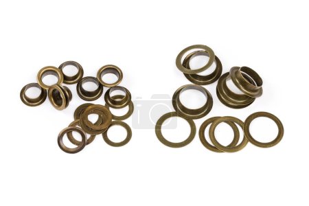 Photo for Heaps of the metal shaped sleeves and washers as eyelets components two different sizes before installation, view on a white background - Royalty Free Image