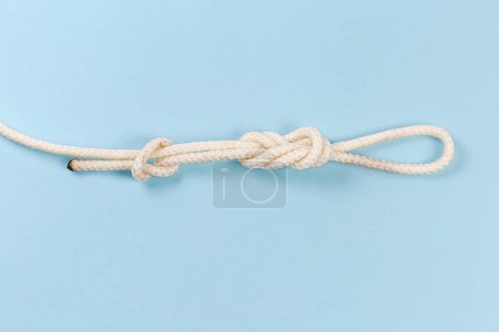 Foto de Rope knot as igure-eight loop, also known as Flemish loop with overhand stopper knot on a blue background - Imagen libre de derechos