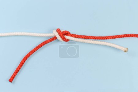 Foto de Rope water knot, also known as tape knot or ring bend on a blue background - Imagen libre de derechos