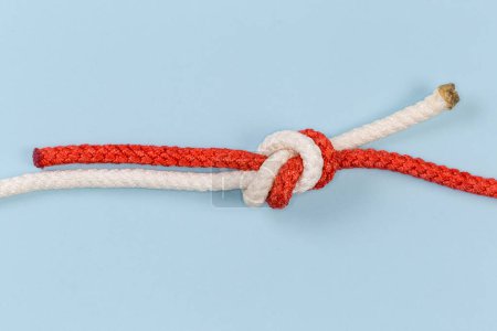 Foto de Rope water knot, also known as tape knot or ring bend, close-up on a blue background - Imagen libre de derechos