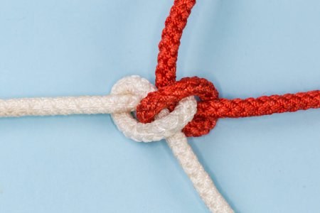 Foto de Tightened rope Hunter's knot used  to join of two ropes, view close-up on a blue background - Imagen libre de derechos