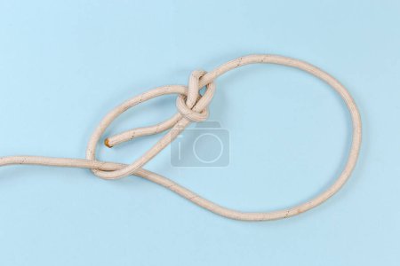 Foto de Rope knot Running bowline used in maritime, view on a blue background - Imagen libre de derechos