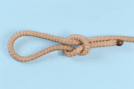 Foto de Rope Noose knot, also known as Running knot on a blue background - Imagen libre de derechos