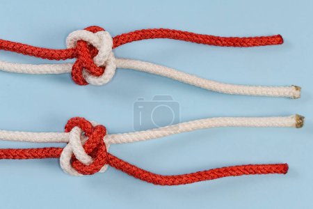 Foto de Tightened decorative rope Diamond knot, also known as Knife lanyard knot, view from two sides on a blue background - Imagen libre de derechos