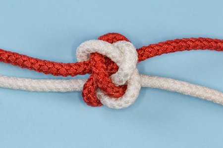 Téléchargez les photos : Tightened decorative rope Diamond knot, also known as Knife lanyard knot, view close-up on a blue background - en image libre de droit