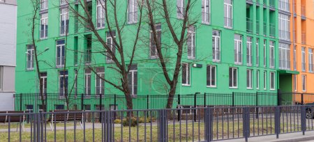 Foto de Fragment of the part of green facades of the modern multistory apartment building lower floors, panoramic view - Imagen libre de derechos