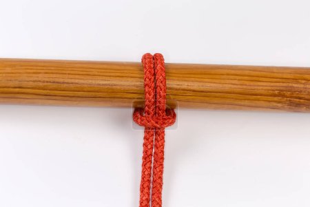 Photo for Rope knot Cow hitch used to attach a rope to an object, tied around a wooden pole on a white background - Royalty Free Image