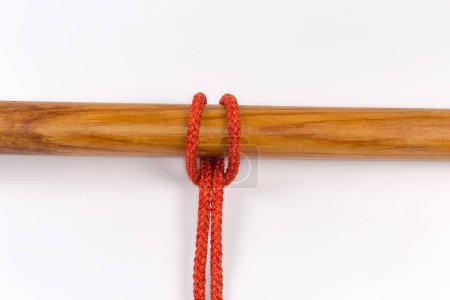 Photo for Rope knot Cow hitch used to attach a rope to an object, tied around a wooden pole on a white background - Royalty Free Image