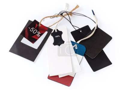Ropa de cartón en blanco swing tags diferentes formas y colores y etiqueta de descuento en las cuerdas colgantes sobre un fondo blanco