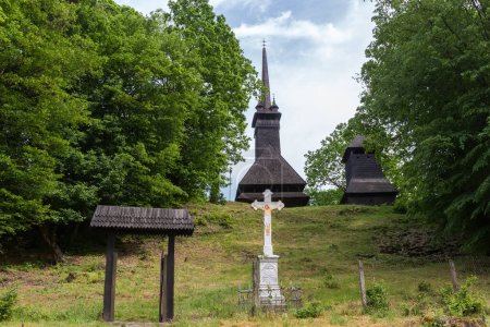 Photo for Gothic two-log wooden Church of the St. Nicholas the Wonderworker of 18th century and wooden bell tower on the hill in the Danylovo village, Ukraine - Royalty Free Image