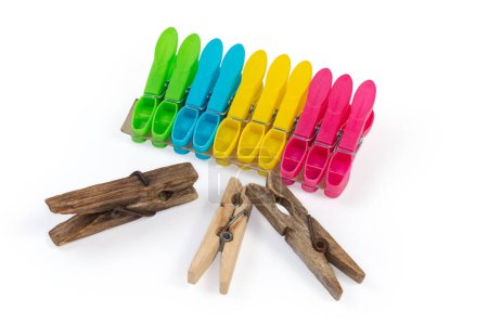 Photo for Old dark wooden clothespins and set of the modern new multi-colored spring-type plastic clothespins on a white background - Royalty Free Image