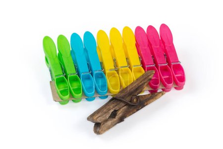Photo for Old dark wooden clothespin and set of the modern new multi-colored spring-type plastic clothespins on a white background - Royalty Free Image