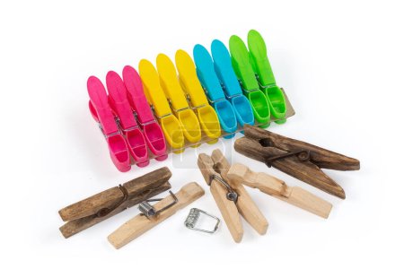 Photo for Old dark wooden clothespins and set of the modern new multi-colored spring-type plastic clothespins on a white background - Royalty Free Image