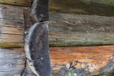 Téléchargez les photos : Fragment de l'ancien noirci avec le temps bûches de bois avec des nœuds et des fissures avec connexion de serrure du coin extérieur des murs de l'ancienne maison, fond, texture - en image libre de droit