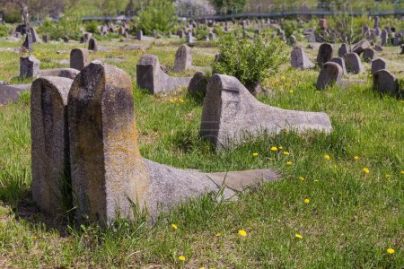 Téléchargez les photos : Vieilles pierres tombales en forme de bottes en feutre sur l'ancien cimetière juif au printemps ensoleillé, Berdychiv, Ukraine - en image libre de droit