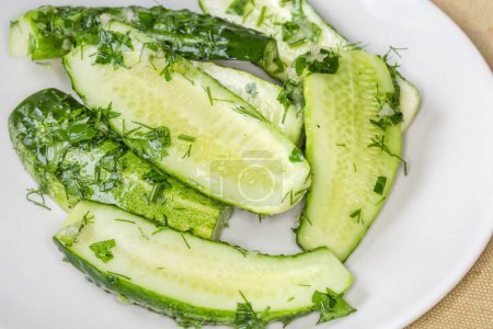 Photo for Semi-pickled, or lightly salted cucumber halves made with short-term salting method on a dish, close-up in selective focus - Royalty Free Image