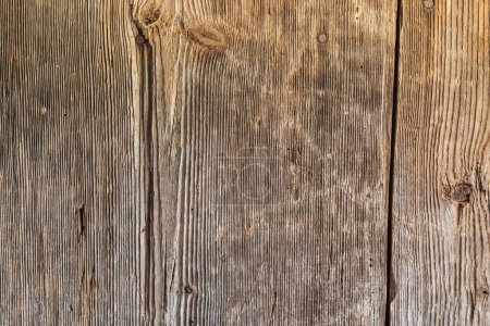 Foto de Superficie de los antiguos tablones de madera con nudos, colocados verticalmente y oscurecidos por el tiempo en un edificio medieval - Imagen libre de derechos
