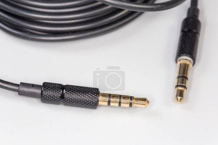 Photo for Gold colored stereo connectors mini jack on the edges of analog audio cable on a gray surface, close-up in selective focus - Royalty Free Image
