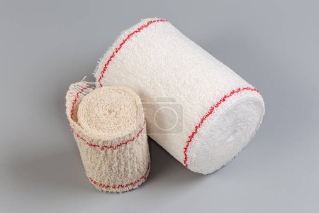 Photo for Two modern woven elastic medical bandages different sizes rolled into rolls on a gray background - Royalty Free Image