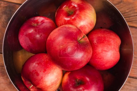 Photo for Washed red apples covered with water drops in the stainless steel kitchen bowl, top view close-up in selective focus - Royalty Free Image