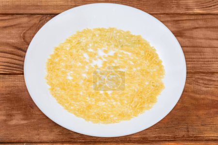 Foto de Pasta cruda en forma de letras mayúsculas del alfabeto inglés y números arábigos vertidos sobre un plato blanco en la mesa rústica, vista superior - Imagen libre de derechos
