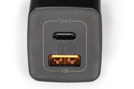 Foto de Panel frontal del cargador negro con dos tomas de salida USB Tipo-A y Tipo-C para la carga de baterías de accesorios portátiles, primer plano del fragmento sobre un fondo blanco - Imagen libre de derechos
