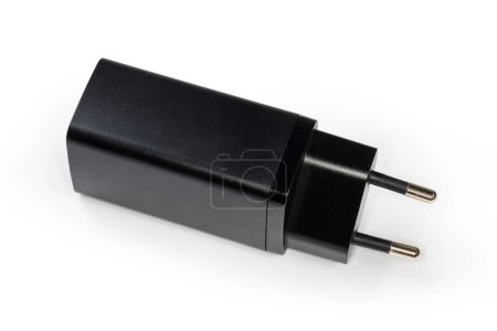 Foto de Cargador negro con conector AC Euro para la carga de baterías de accesorios electrónicos portátiles, primer plano sobre un fondo blanco - Imagen libre de derechos