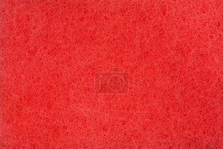 Téléchargez les photos : Texture du matériau synthétique rouge de l'éponge de nettoyage abrasive à l'uréthane dur de cuisine, vue de dessus gros plan - en image libre de droit