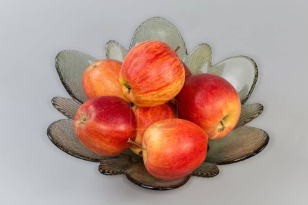 Photo for Whole red apples in the glass bowl for fruits on a gray background - Royalty Free Image