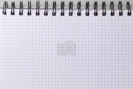 Foto de Hoja en blanco de papel cuadrado de un libro de ejercicios escolares o cuaderno de papel con encuadernación en espiral de alambre negro, vista superior - Imagen libre de derechos