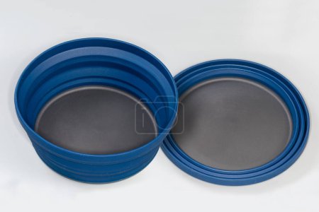 Photo for Two empty tourist foldable bowls made of food-grade flexible thermosilicone in the folded and unfolded state on a gray surface - Royalty Free Image
