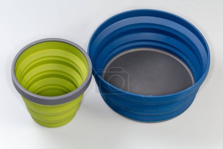 Photo for Camp set of empty foldable bowl and cup made of durable food-grade flexible thermosilicone in the unfolded state on a gray surface - Royalty Free Image
