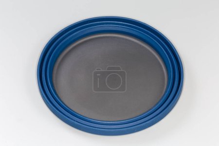 Photo for Empty tourist foldable bowl made of food-grade flexible thermosilicone in the folded state on a gray surface - Royalty Free Image