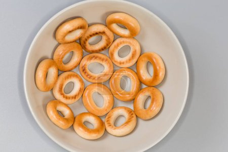 Crunchy ring shaped small cookies, so called sushki in bowl, top view on a gray background close-up