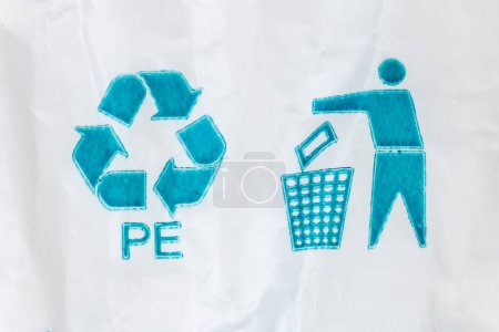 Blaues universelles Recycling-Symbol mit Recycling-Code und aufgeräumtes Männchen-Symbol zur Entsorgung von Verpackungen in der Abfalltonne auf weißem Polyethylen-Beutel abgebildet