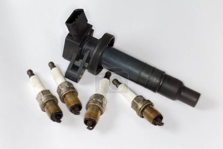 Used ignition coil of coil-on-plug system and spark plugs for petrol internal combustion engine of modern car on a white background