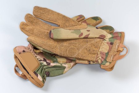 Paar beige taktische Militärhandschuhe aus Textil und Kunstleder auf grauem Hintergrund