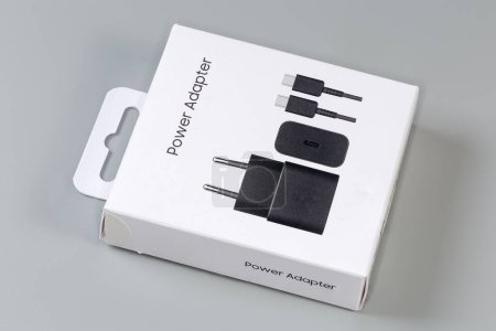 Boîte d'emballage à languette rectangulaire fermée en carton blanc pour chargeur USB avec prise AC Euro sur une surface grise